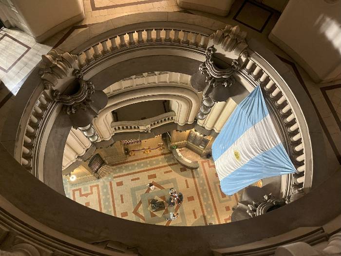 A group of visitors and the Argentinean flag seen from above in a classic building (Buenos Aires)